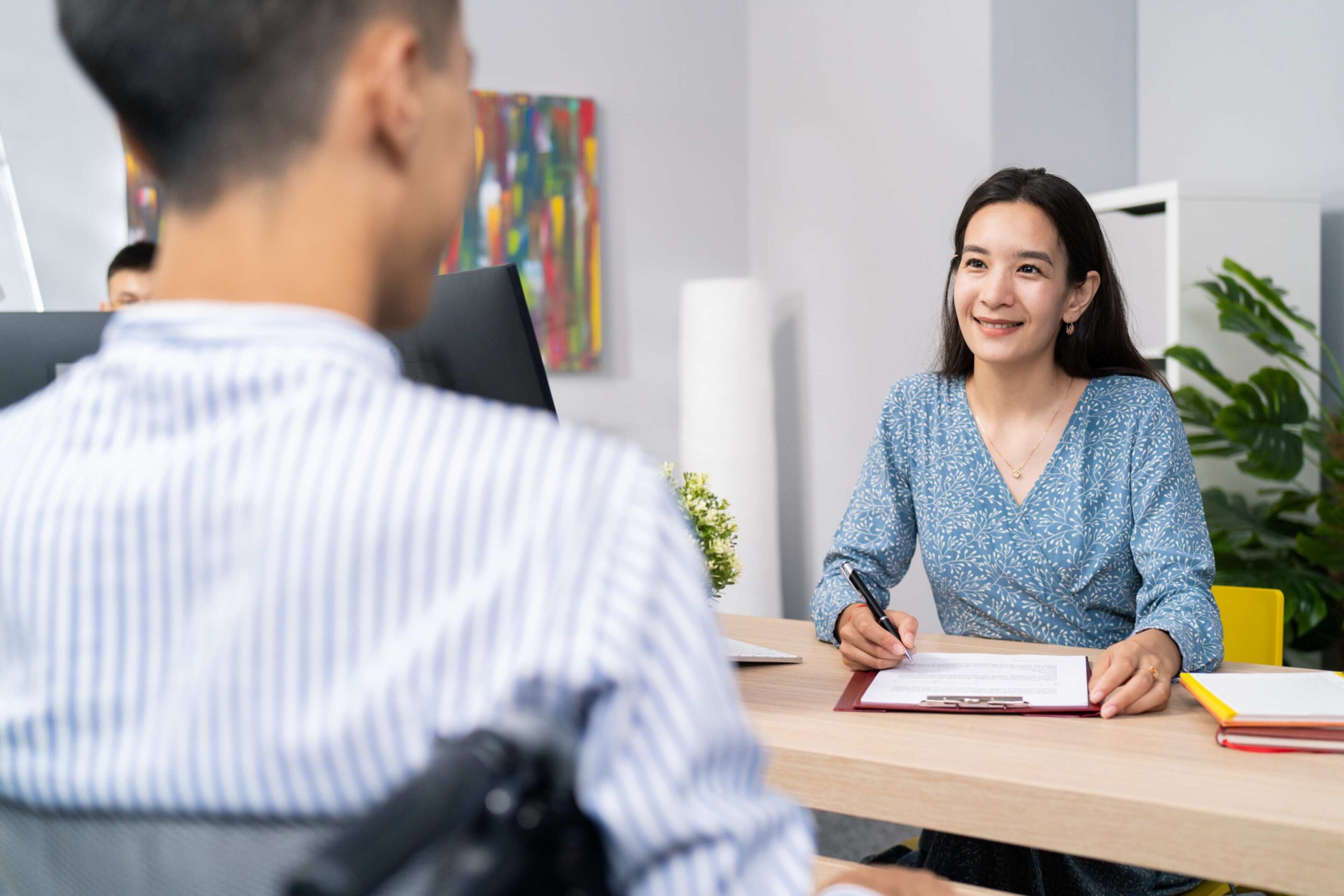 Woman signing document during job interview.