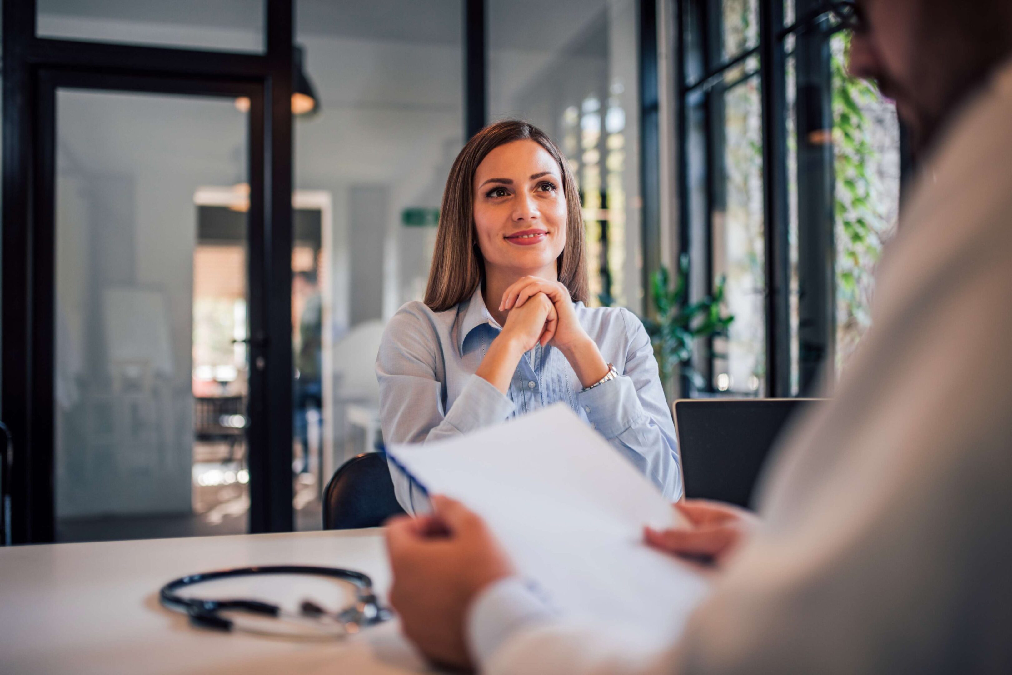 Woman listening attentively to doctor during consultation.