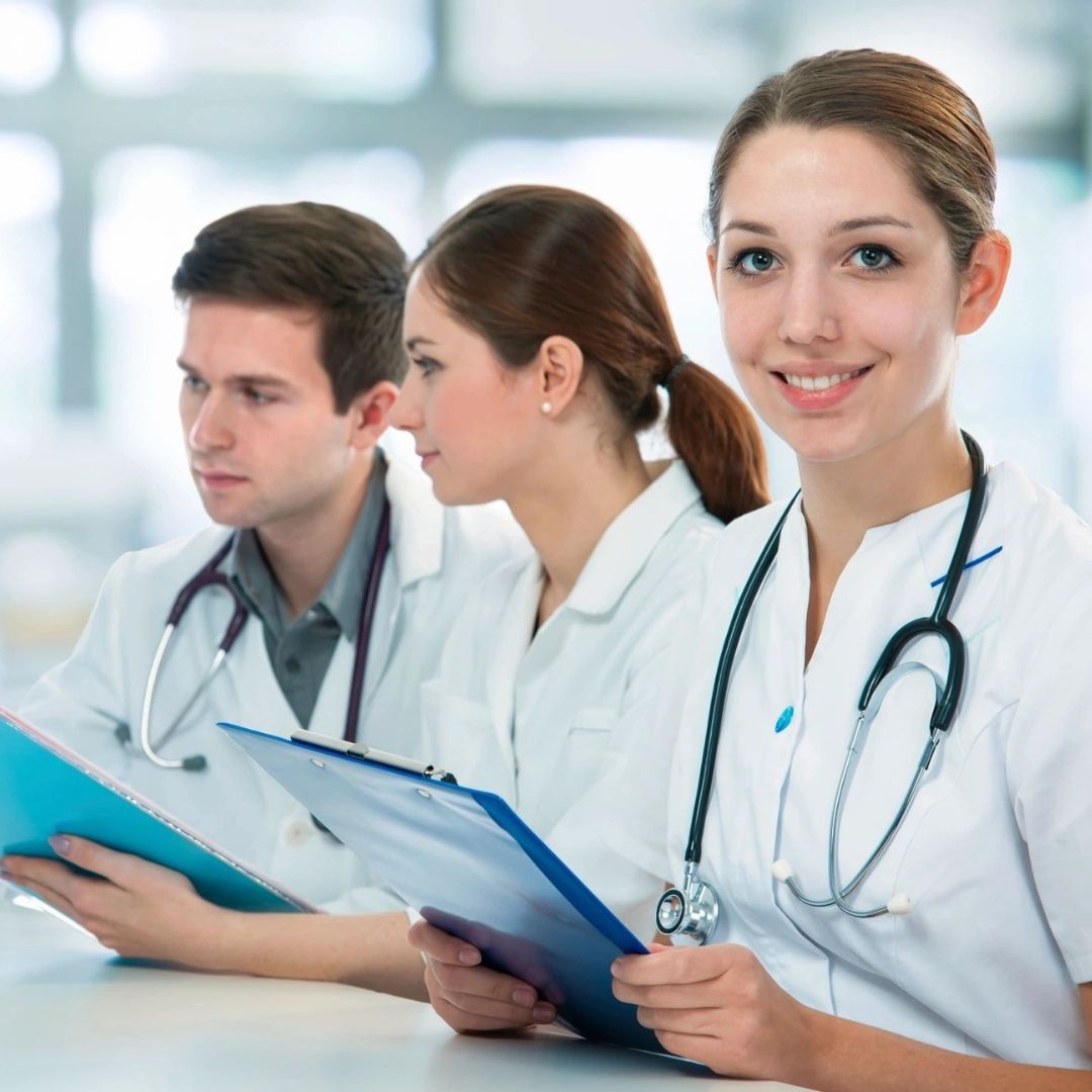 Smiling female doctor with colleagues.